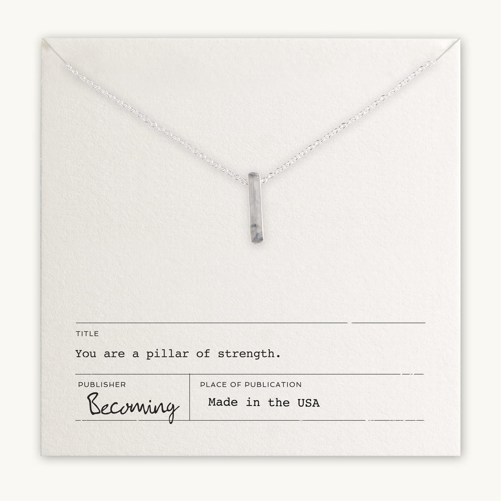 Becoming Jewelry's Pillar of Strength Necklace is a sterling silver necklace with a hammered bar drop charm on a fine cable chain, displayed on a card with the inspirational message, "you are a pillar of strength.