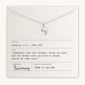 Becoming Jewelry's Over the Rainbow Necklace, with a Rainbow Charm pendant displayed on a card featuring a quote about dreams and a rainbow, labeled as made in the USA.