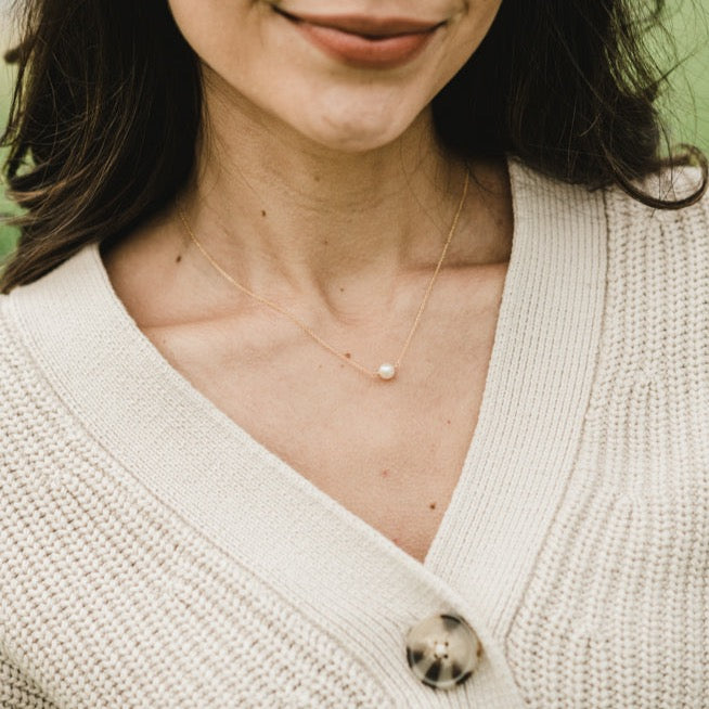 Woman wearing a Becoming Jewelry Simple Pleasures Pearl Necklace with a single freshwater pearl.