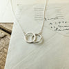 Becoming Jewelry's Joined for Life Necklace charm necklace on a piece of paper with handwritten notes.