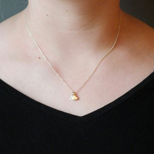 A person wearing a black top and a delicate Becoming Jewelry Tiny Hearts Necklace.