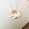 Becoming Jewelry's Gold-filled Sun Moon and Stars Necklace on wooden surface.