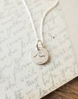 Swim the Sea Necklace by Becoming Jewelry mustache pendant necklace on a handwritten letter background.